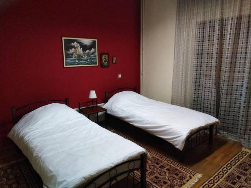 Κεντρικο ΔΙΑΜΕΡΙΣΜΑ ΣΤΑ ΤΡΙΚΑΛΑ في تريكالا: سريرين في غرفة ذات جدران حمراء