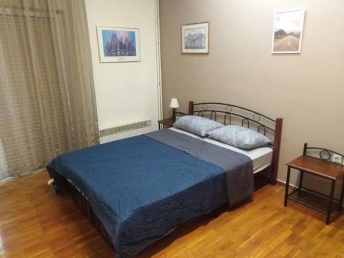 Κεντρικο ΔΙΑΜΕΡΙΣΜΑ ΣΤΑ ΤΡΙΚΑΛΑ في تريكالا: غرفة نوم بسرير وبطانية زرقاء وطاولة