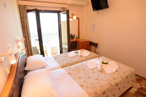 a bedroom with a bed with towels on it at Sappho Hotel in Skala Eresou