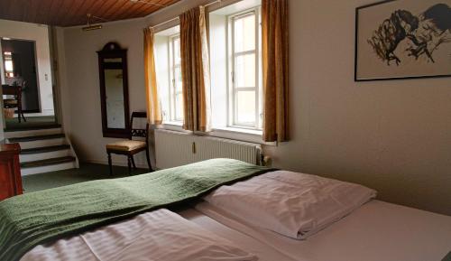 a bedroom with a bed in a room with a window at Hotel Ærø in Svendborg
