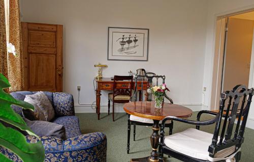 a living room with a table and chairs and a table at Hotel Ærø in Svendborg