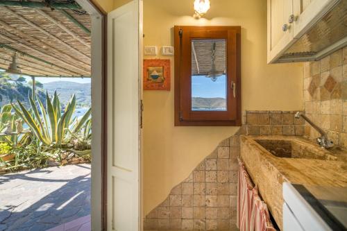 a kitchen with a sink and a window at Agave direclty on the beach - Goelba in Portoferraio