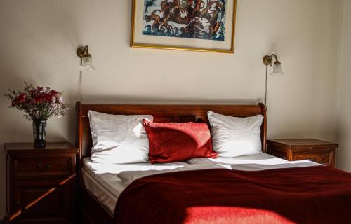 a bedroom with a bed with two red pillows at Hotel Ærø in Svendborg
