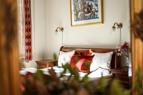 a bedroom with a bed with a red pillow at Hotel Ærø in Svendborg