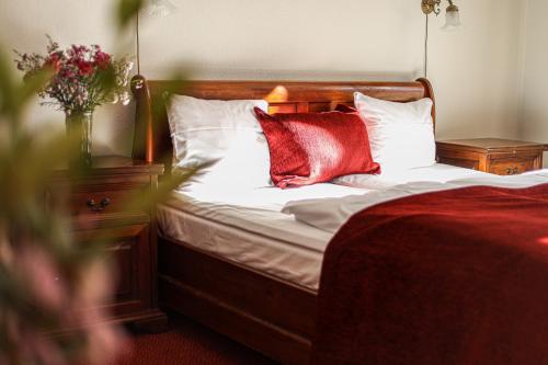 a bedroom with a bed with two red pillows at Hotel Ærø in Svendborg