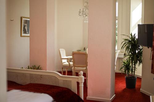 a room with a bed and a table with chairs at Hotel Ærø in Svendborg