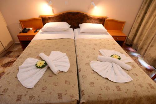 a bedroom with a bed with towels on it at Sappho Hotel in Skala Eresou