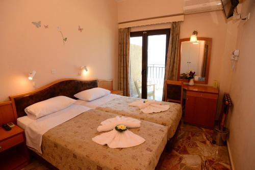 a bedroom with a bed with a flower on it at Sappho Hotel in Skala Eresou