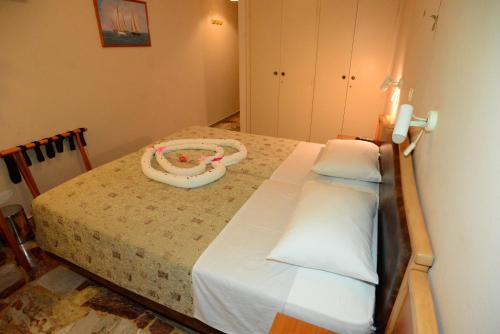 a bedroom with a bed with a pacifier on it at Sappho Hotel in Skala Eresou