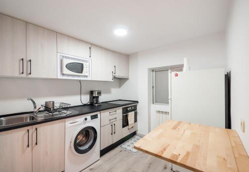 馬德里的住宿－Apartamento Madrid Centro - Barrio de Las Letras，厨房配有白色橱柜、水槽和冰箱。