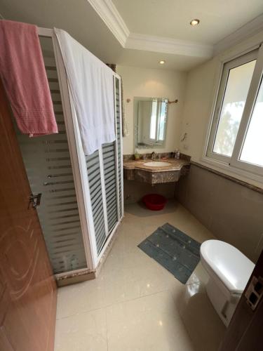 a bathroom with a toilet and a sink and a window at Palm Resort in Sharm El Sheikh