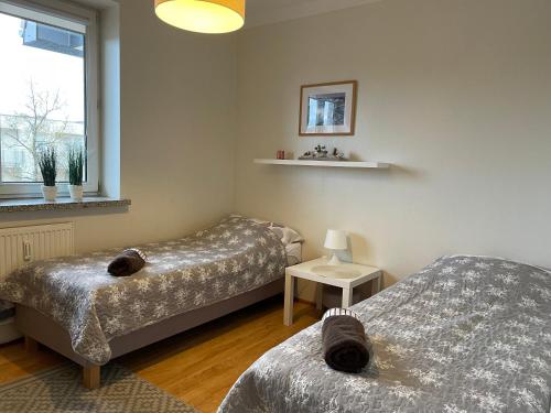 a bedroom with two beds and a window at Apartament Mieszka in Kołobrzeg