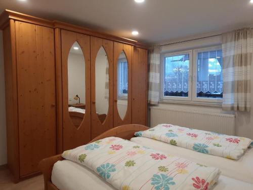 een slaapkamer met 2 bedden en 2 spiegels bij Haus Amann in Prackenbach
