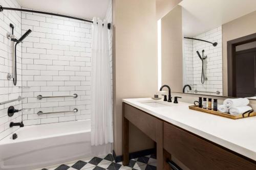 a bathroom with a sink, toilet and bathtub at Origin Red Rocks, a Wyndham Hotel in Golden