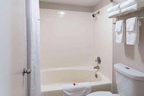 a white bathroom with a tub and a toilet at Travelodge by Wyndham Florence in Florence