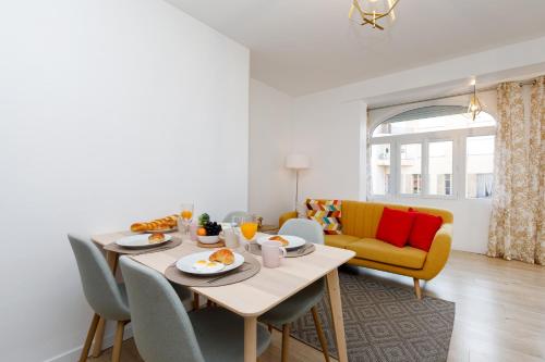 une salle à manger avec une table, des chaises et un canapé dans l'établissement Lumière YourHostHelper, à Cannes