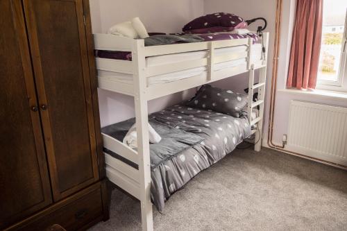 a bedroom with two bunk beds in a room at Moorings in Fairbourne