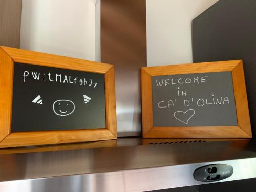 two framed signs sitting on top of a counter at B & B CA’ D’ OLINA in Pavullo nel Frignano
