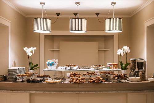 a buffet with many different types of cakes and desserts at Hotel De La Ville in Riccione