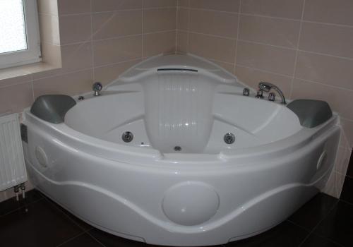 a large white bath tub in a bathroom at Cottage Resort Spas Kamenka in Spas-Kamenka