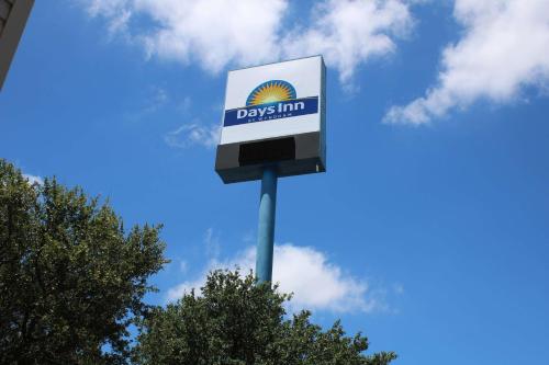 a sign for a daylin gas station on a pole at Days Inn by Wyndham Waco University Area in Waco