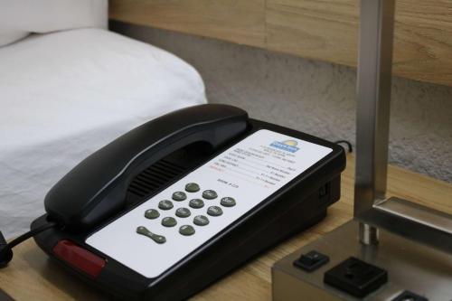 a phone sitting on a table next to a bed at Days Inn by Wyndham Waco University Area in Waco