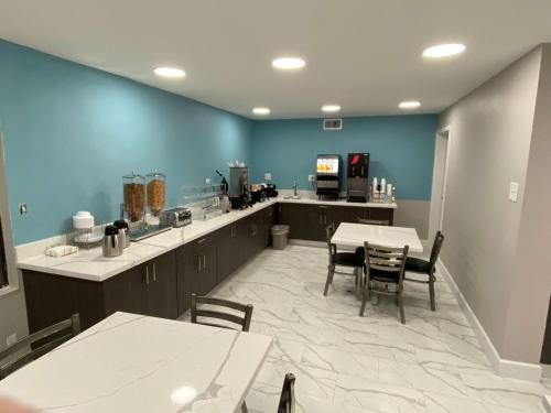 a kitchen with tables and chairs and a blue wall at Days Inn by Wyndham Waco University Area in Waco