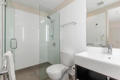 y baño con aseo, lavabo y ducha. en The Waterfront - Paihia Holiday Apartment en Paihia