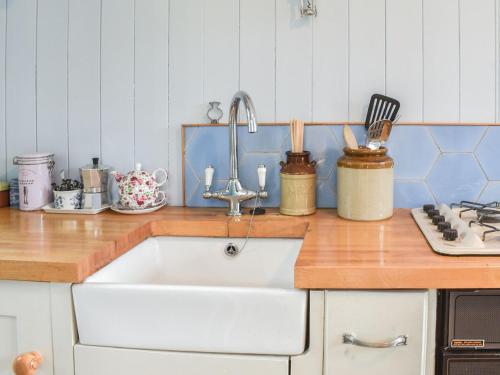 a kitchen with a sink and a counter top at Farmhouse Garden Shepherds Hut in Thursley