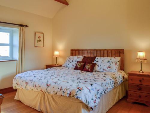 a bedroom with a bed and two lamps and a window at Clover Hill Farm in Coanwood