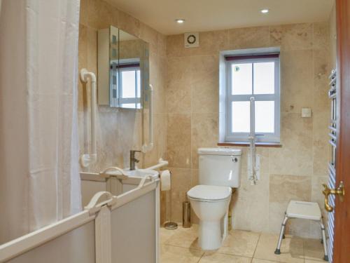 a bathroom with a toilet and a tub and a sink at Clover Hill Farm in Coanwood