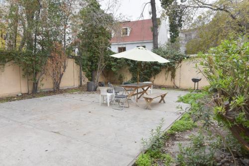 a patio with an umbrella and a table and chairs at Habitacion amoblada Providencia - Metro Salvador in Santiago