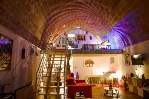 Habitación con una escalera que conduce a un dormitorio. en Il Risveglio nei Sassi en Matera