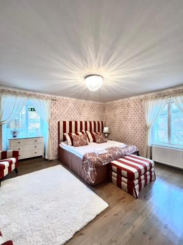 a bedroom with a bed and a rug and windows at Mukkulan kartano in Lahti