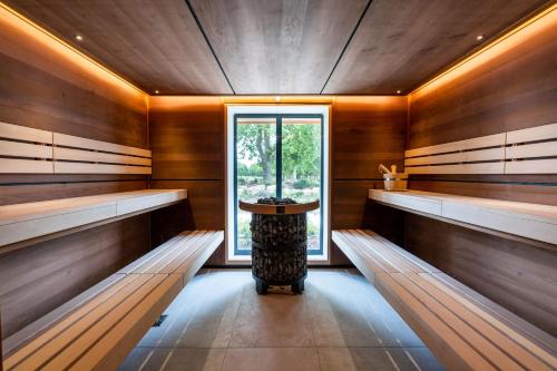 a sauna with wooden walls and a window and benches at Laceby Manor - Spa & Golf Resort in Laceby