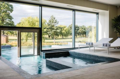 a pool with a view of a house at Laceby Manor - Spa & Golf Resort in Laceby