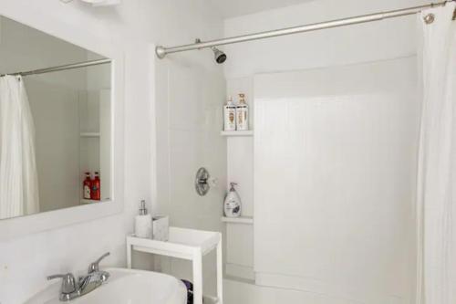 a white bathroom with a shower and a sink at Newly Renovated Basement with Private Bathroom in Herndon