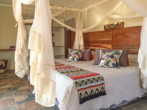 a bedroom with a bed with a canopy at Okutala Etosha Lodge in Outjo