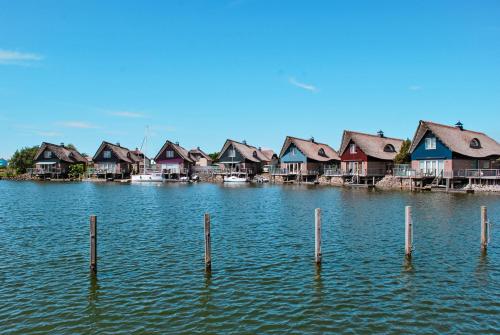 een rij huizen op een meer met palen in het water bij Beach Resorts Makkum in Makkum