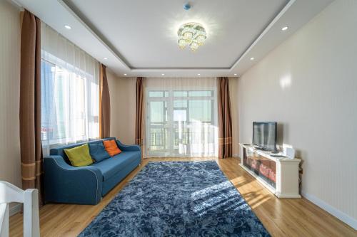 a living room with a blue couch and a tv at Eagle Town Serviced Apartment- Free Pick up from Airport in Ulaanbaatar