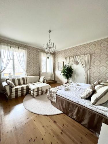 um quarto grande com uma cama grande e um sofá em Mukkulan kartano em Lahti