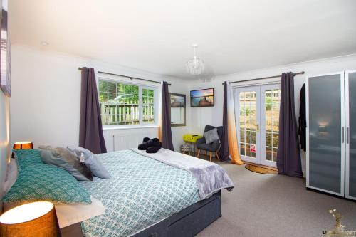 a bedroom with a large bed and a window at Station Lodge close to City Centre with parking in Exeter