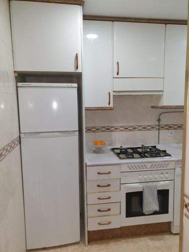 a kitchen with white cabinets and a stove and a refrigerator at Hermosa Habitación A individual. Getafe centro.Cerca del metro y Renfe in Getafe