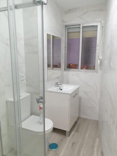Baño blanco con aseo y lavamanos en Hermosa Habitación A individual. Getafe centro.Cerca del metro y Renfe, en Getafe