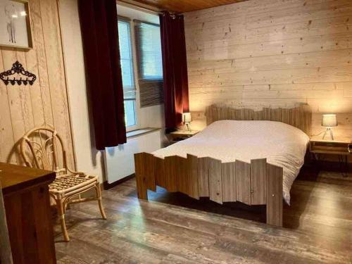 ein Schlafzimmer mit einem Bett und einer Holzwand in der Unterkunft Le Nordmann - au coeur de Gérardmer in Gérardmer