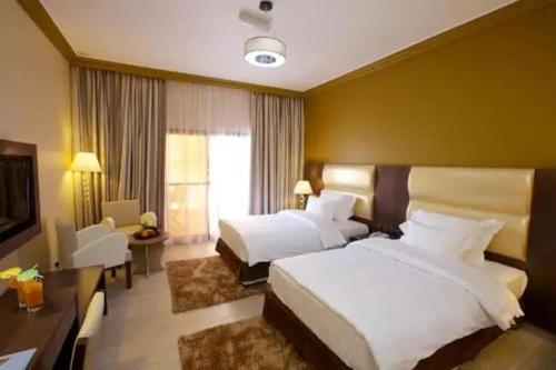 カイロにあるUp Town Hotelのベッド2台とテレビが備わる広いホテルルームです。