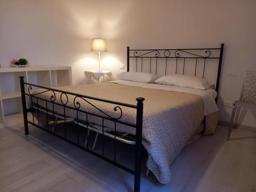 ein Schlafzimmer mit einem schwarzen Bett und einer weißen Decke in der Unterkunft L' Antico Comune in Cavriglia