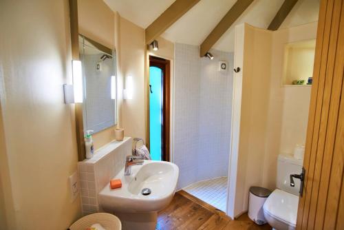 a bathroom with a white sink and a shower at Finest Retreats - Buzzard Luxury Treehouse Hideaway in Dittisham