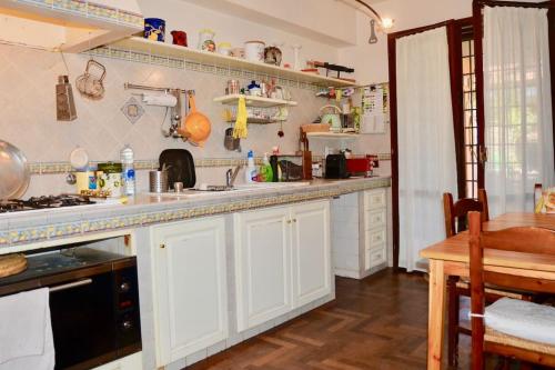 a kitchen with white cabinets and a table in it at Ameno house in Casale SantʼAntonio