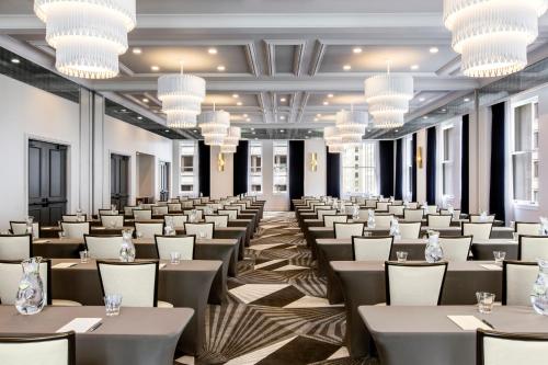 a large room with tables and chairs and chandeliers at Kimpton Gray Hotel Chicago by IHG in Chicago